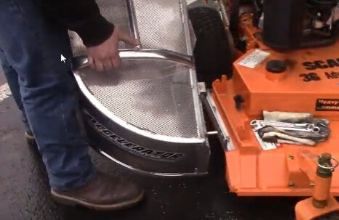 Grass catcher being installed on mower
