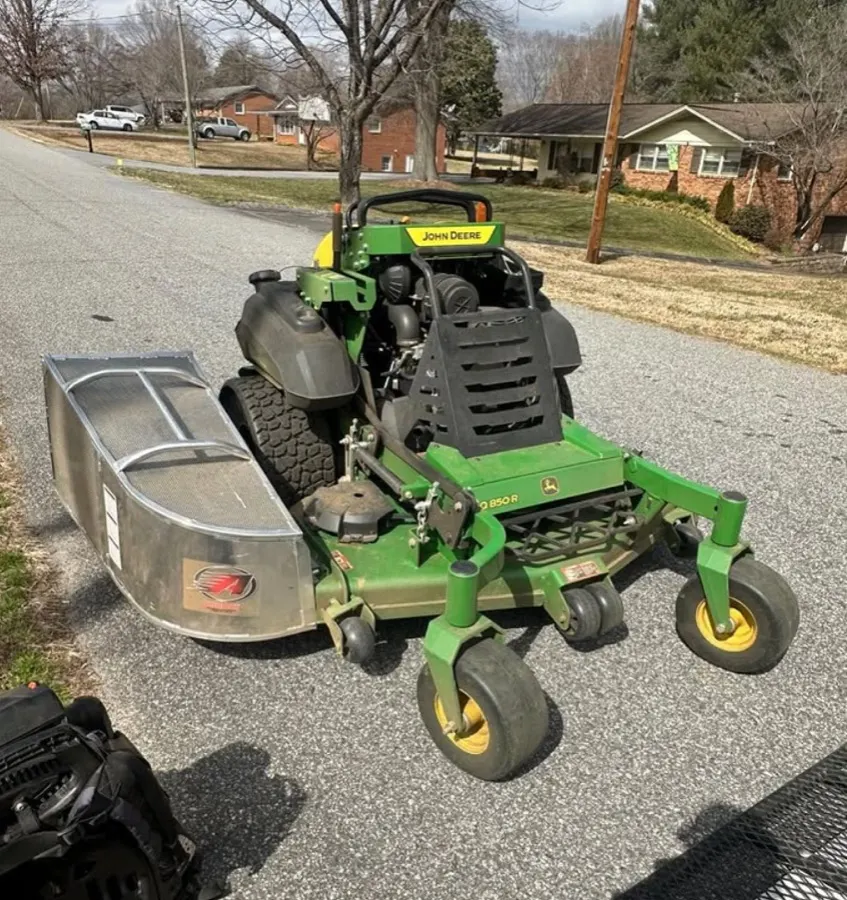 John Deere stand-on mower with an Accelerator grass catcher installed